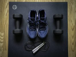 Photo of athletic shoes and weights next to a jump rope