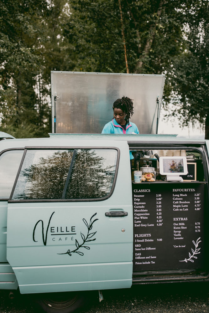 Aimerance Merveille Ngalula serving coffee out of her van-based business, Veille Café