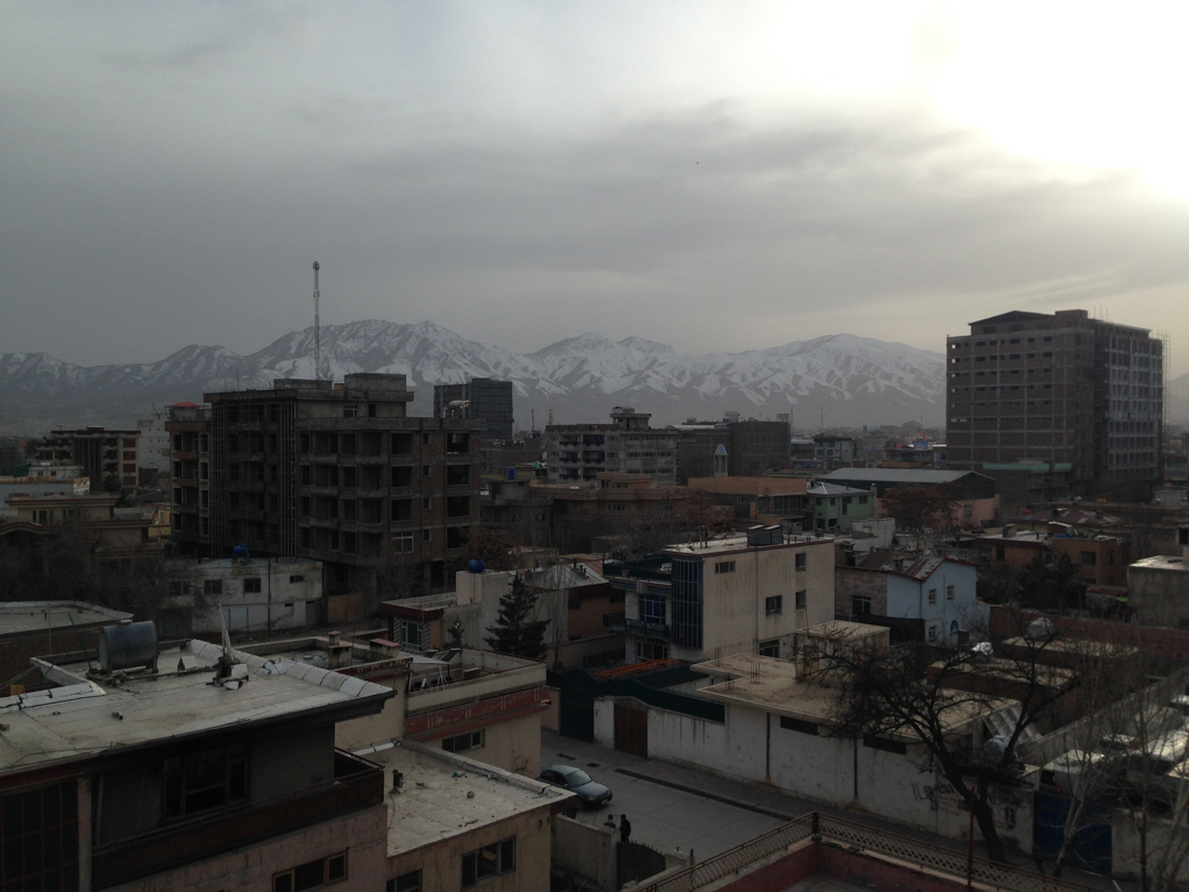 Photo of a cityscape in Afghanistan, with snow-capped mountains in the background