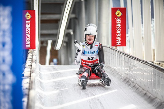 Photo of Trinity Ellis waving from a luge