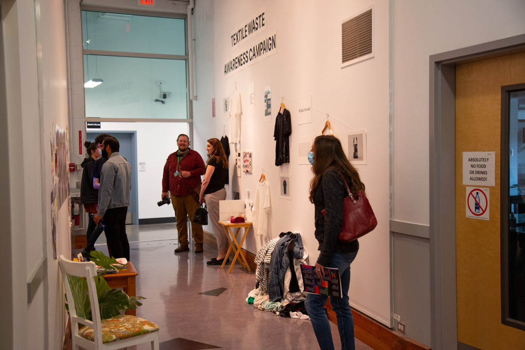 Photo of people looking at artwork along a hallway at UFV