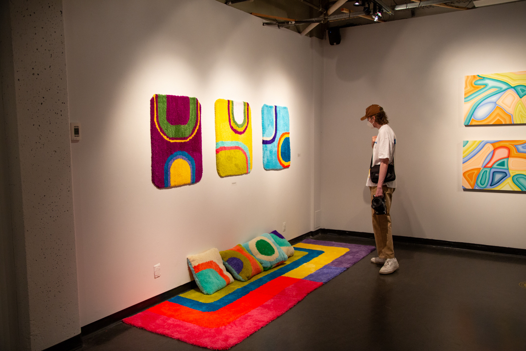 Photo of a person in a gallery looking at textiles on display