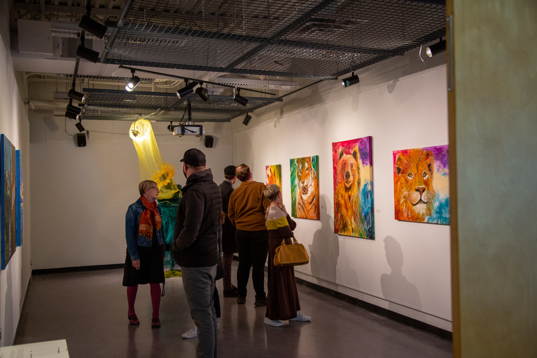Photo of people looking at artwork at the on a gallery wall