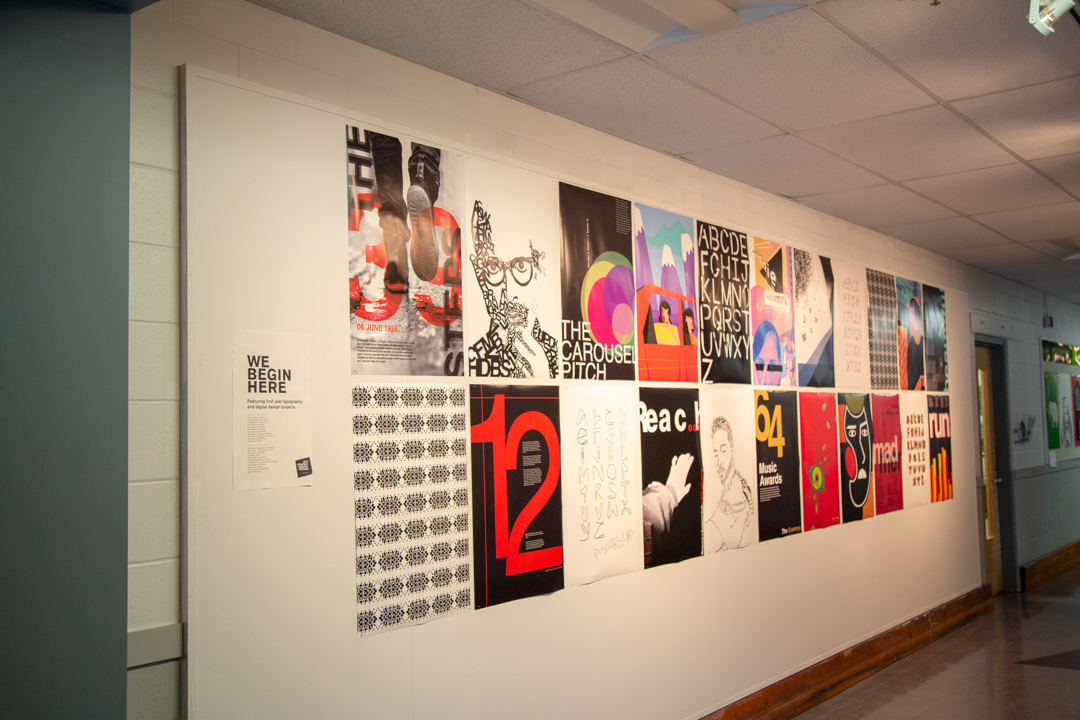 Photo of a wall of different artistic posters showing first year students' work