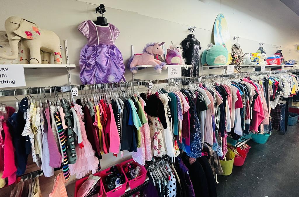 An assortment of children's clothes on a clothing rack