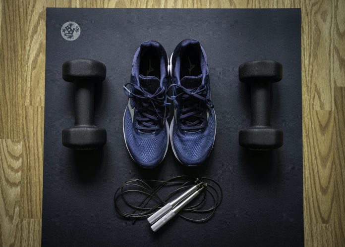 Photo of athletic shoes and weights next to a jump rope