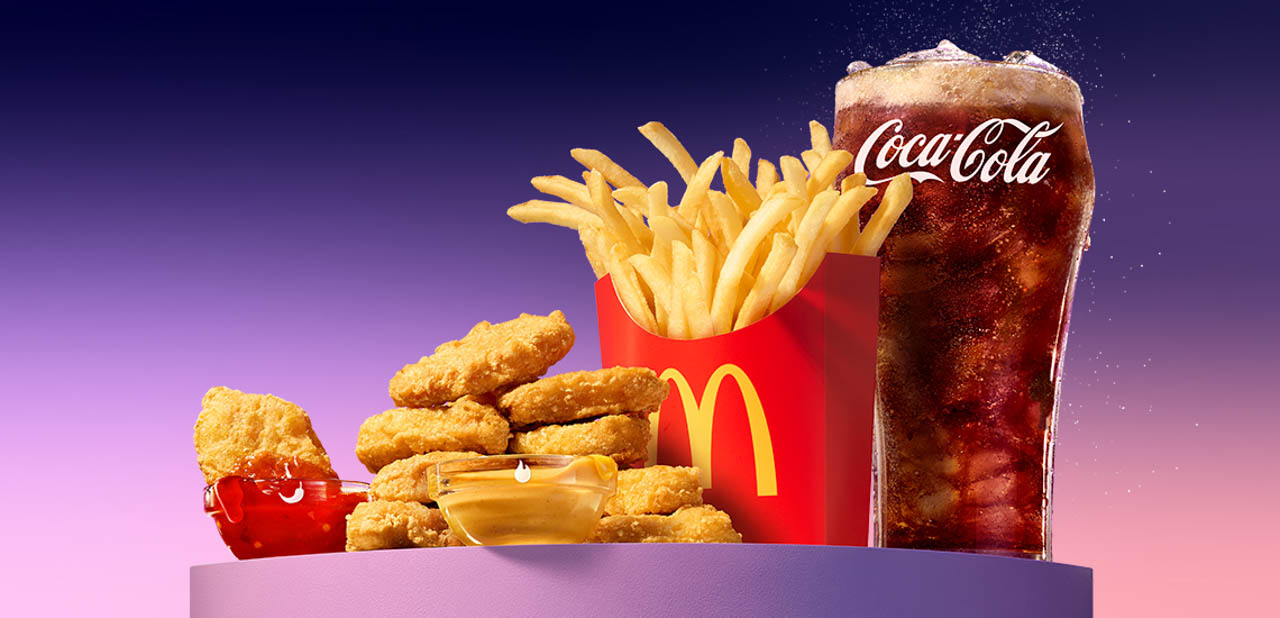 Promotional photo of the McDonalds BTS meal with chicken nuggets, fries, and a glass of Coca-Cola.