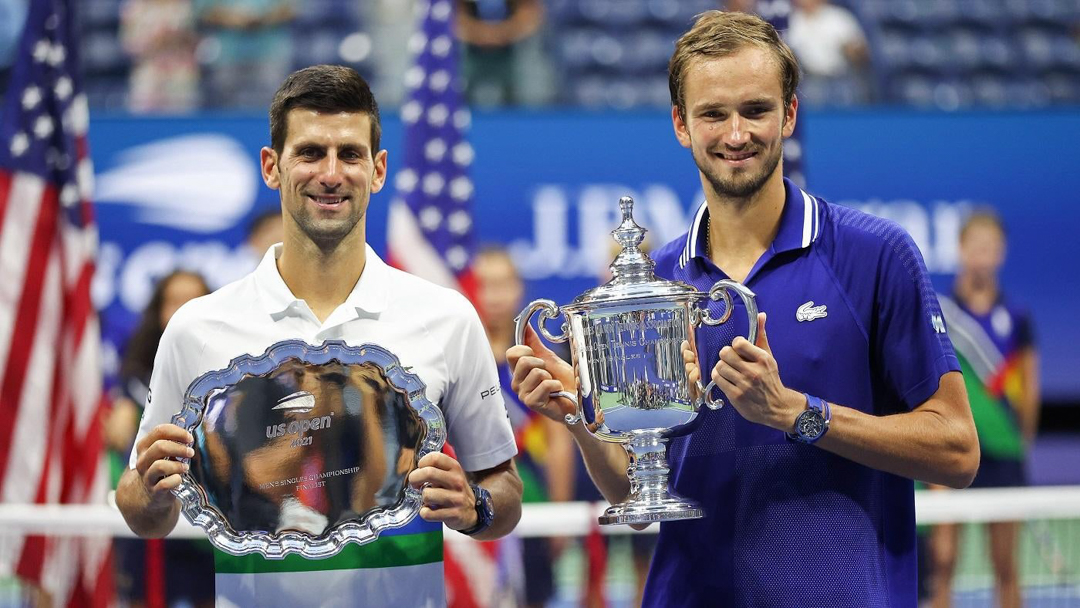 Daniil Medvedev and Novak Djokovic holding trophies