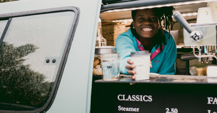 Aimerance Merveille Ngalula serving coffee out of her van-based business, Veille Café