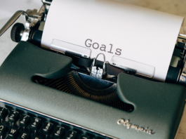Photo of a typewriter with paper that has typed the word "goals"