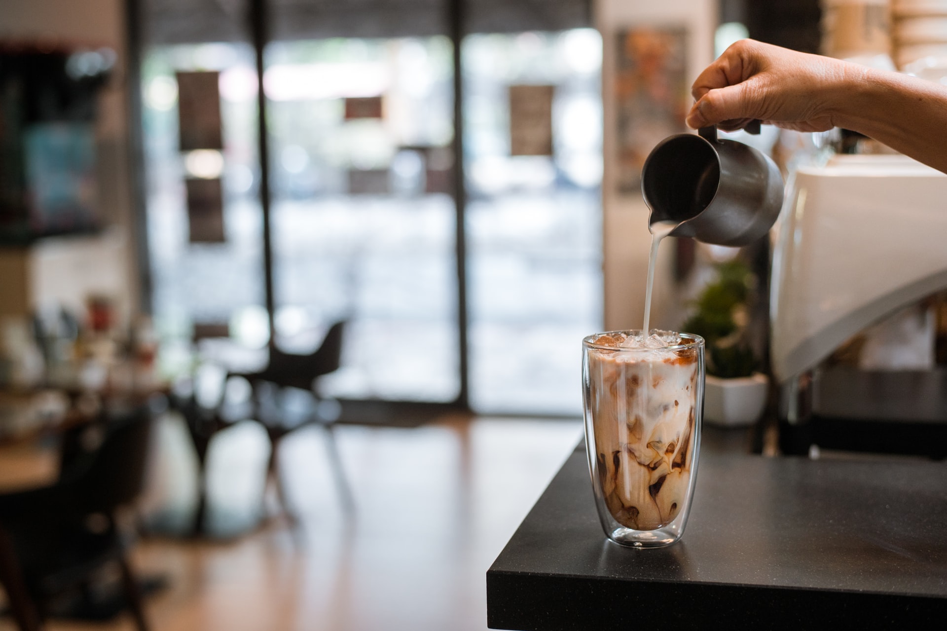 Photo of a barista pouring an iced coffee