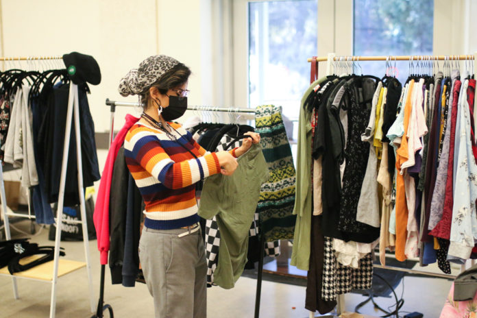 Photo of a person looking at clothing on a rack