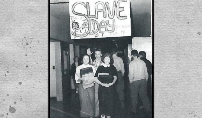 Historical photo of students walking in a hall at Chilliwack highschool in 1950s, with a large sign overhead that reads 