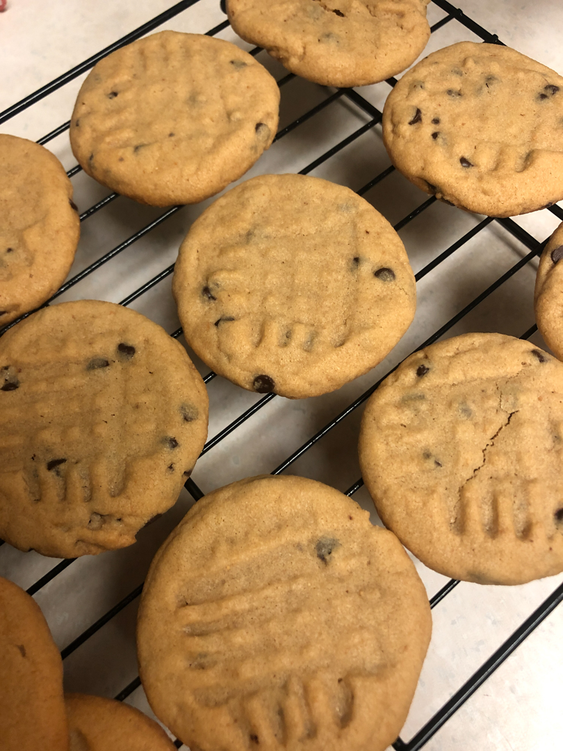 Photo of peanut butter chocolate chip cookies on a baking sheet.