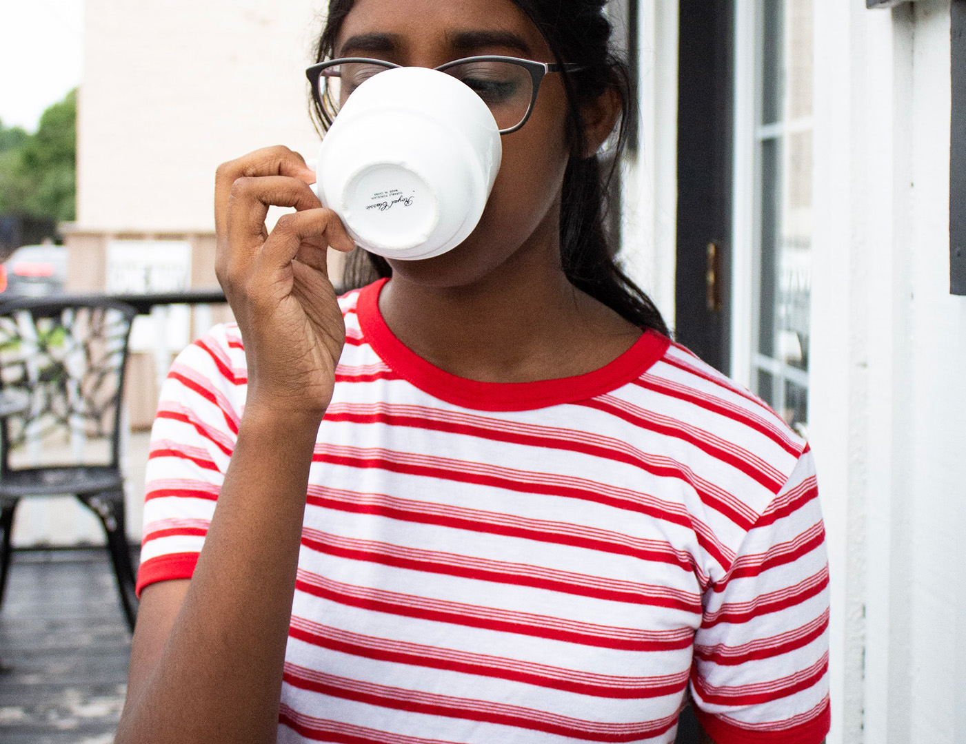 Photo of a person in a striped shirt drinking coffee
