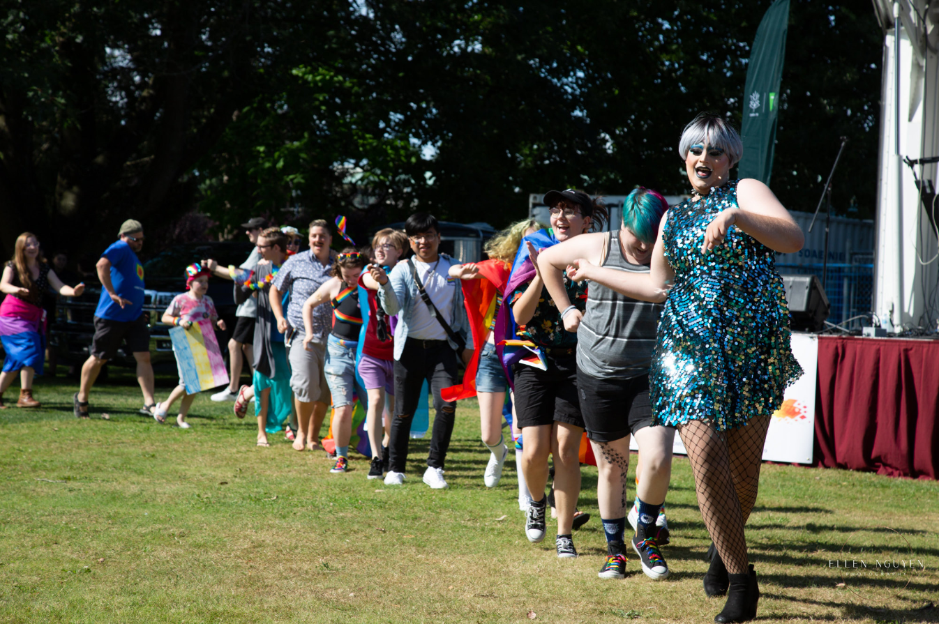 Photo of a line of people dancing in a park at Pride 2019