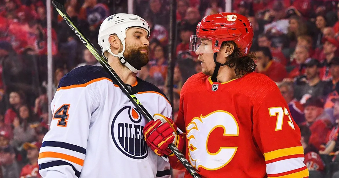 Photo of an Edmonton Oilers player and a Calgary Flames player staring each other down on the ice.