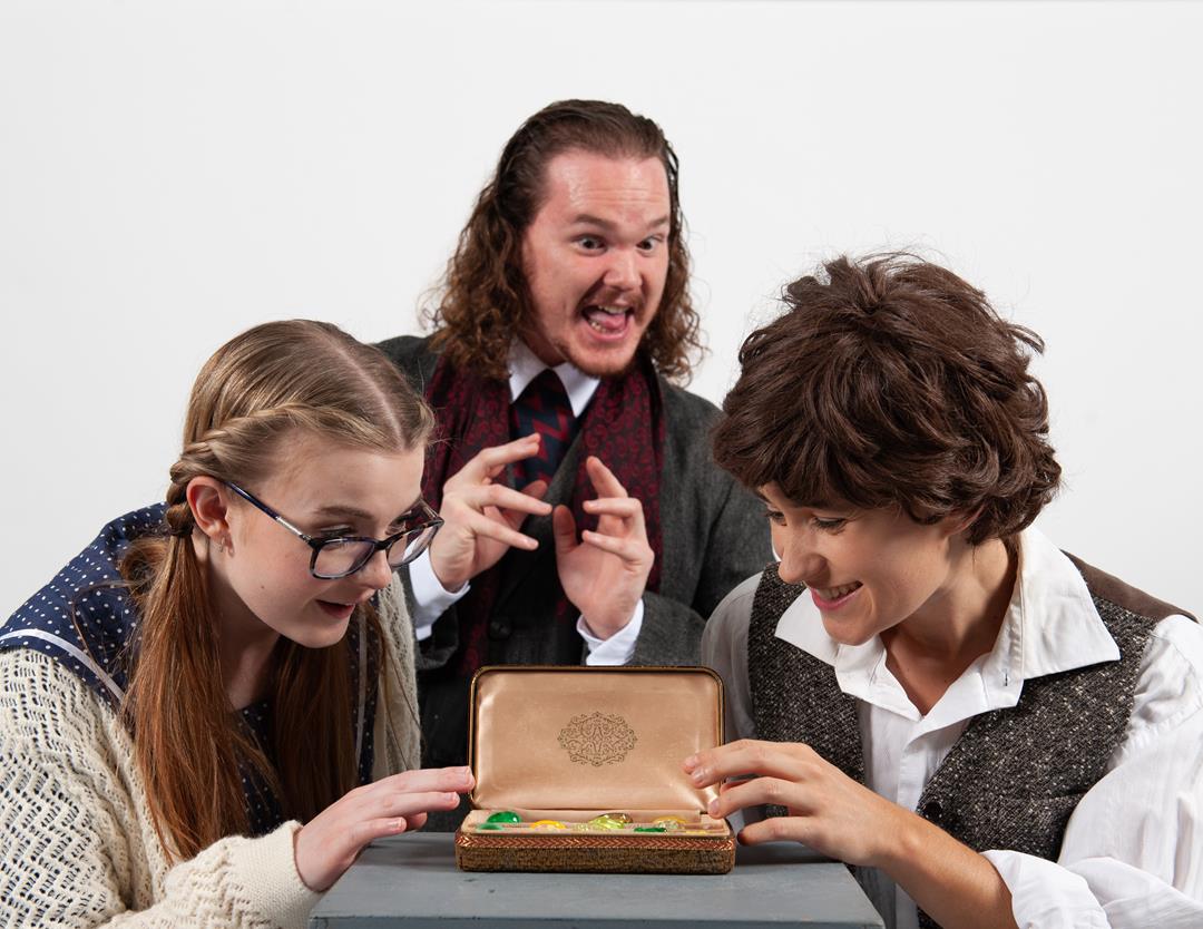 (left to right) Shana Pierce, Marcus Miller and Rebecca Dougan perform in Gallery 7 Theatre's production of The Magician's Nephew. Hovered over a case with clear green items in it.