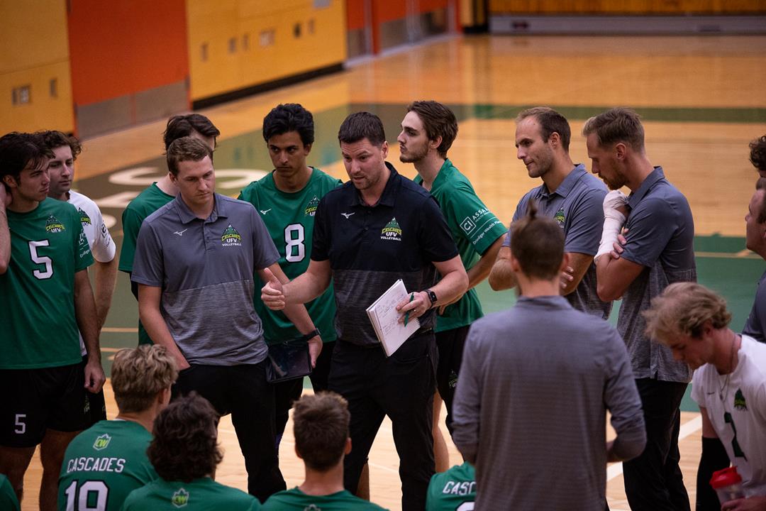 Head Coach Nathan Bennet huddles and encourages the Men's Volleyball team during a timeout.
