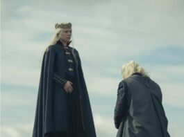 A blonde character kneels to a blonde king outside on a grassy hill.
