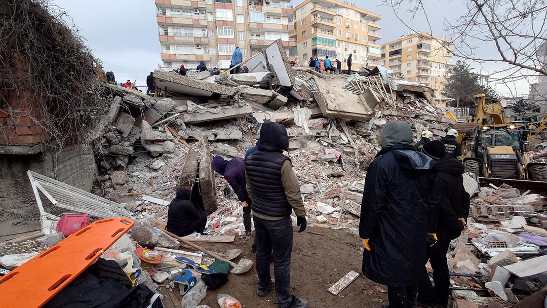 Onlookers view a pile of rubble in the aftermath of the earthquake in Turkey and Syria.