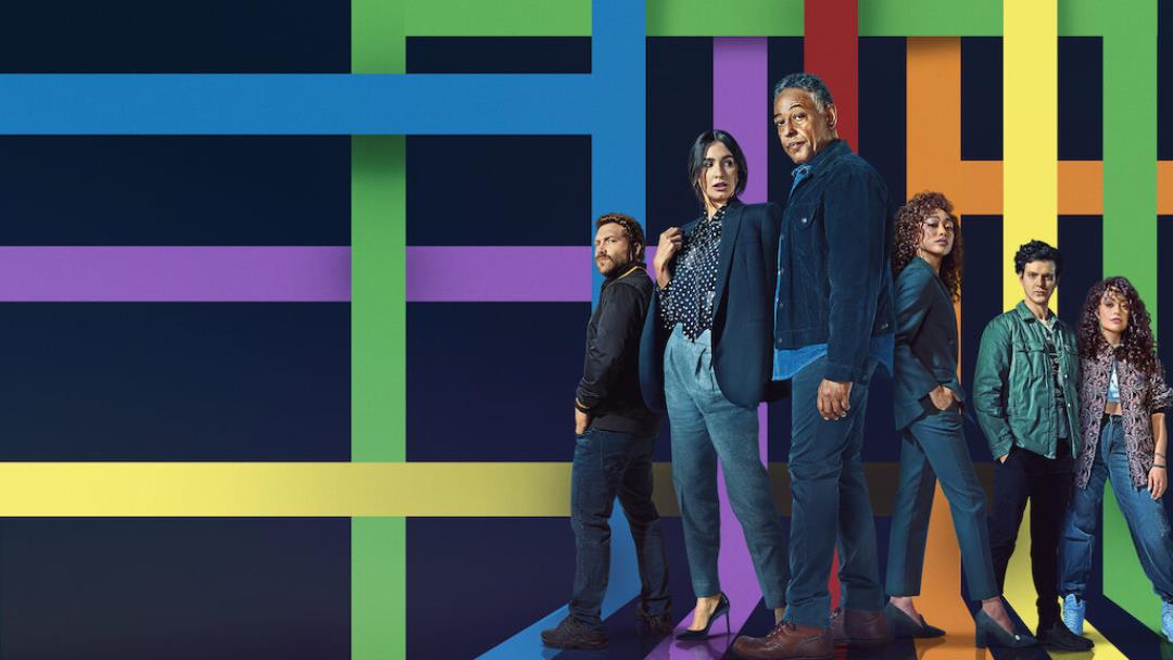 The cast stands in a v formation and behind them are different intersecting lines in rainbow colors going across the screen