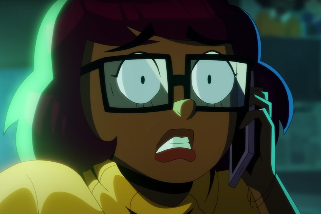 An animated velma is backlit with a neon green light. Her face is looking surpised.