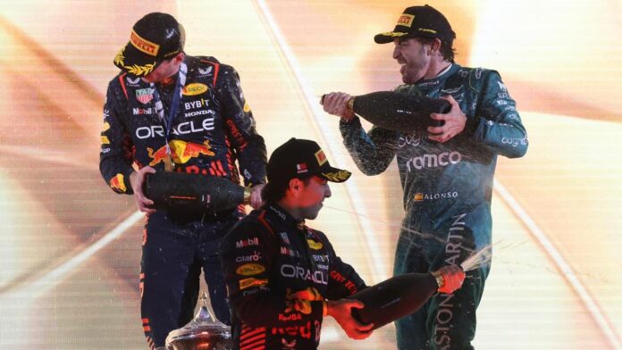 F1 Racers spraying champagne on each other with glee
