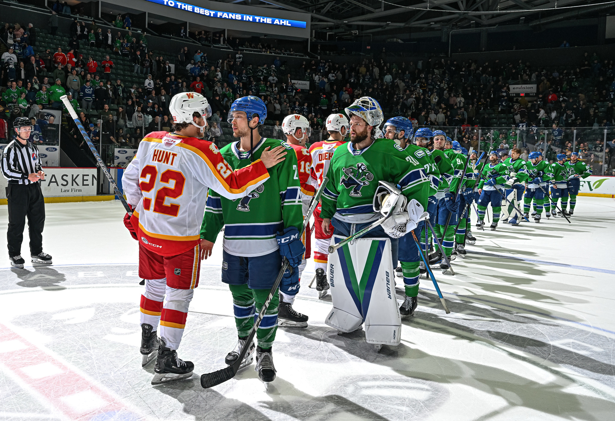 Abbotsford Canucks captain Chase Wouters shakes hands with Calgary Wranglers' Hunt at the end of Game 4.