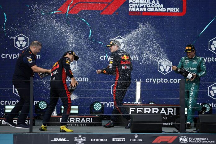 Max Verstappen, Sergio Perez, and Fernando Alonso spray champagne on the Miami Grand Prix podium Sunday
