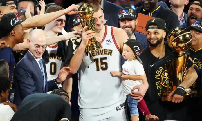Nikola Jokic raises the NBA Finals MVP trophy after his team, the Denver Nuggets wins their first NBA championship.
