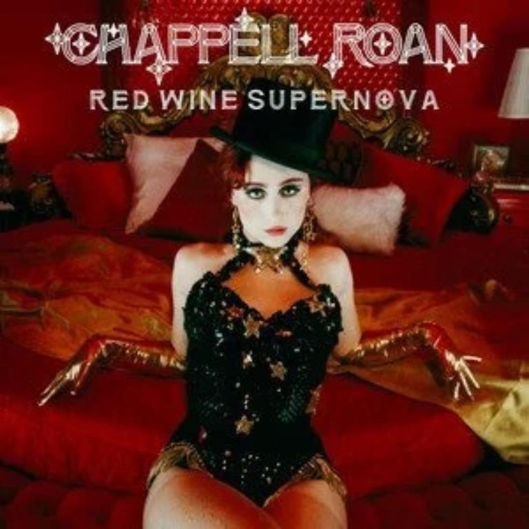Album cover, Chapelle Raon sits on a bed. The room is read and the bed has red sheets, she wears a top hat and a black corset. Her makeup is done in 1920's fashion.