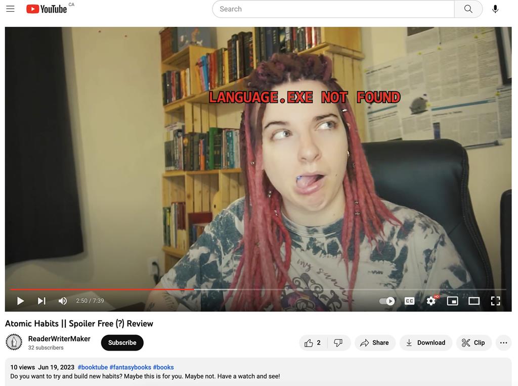 A screen grab of ReaderWriterMaker's Youtube channel from a recent video. She is making a face with her tounge out and red text over lays her face saying 
