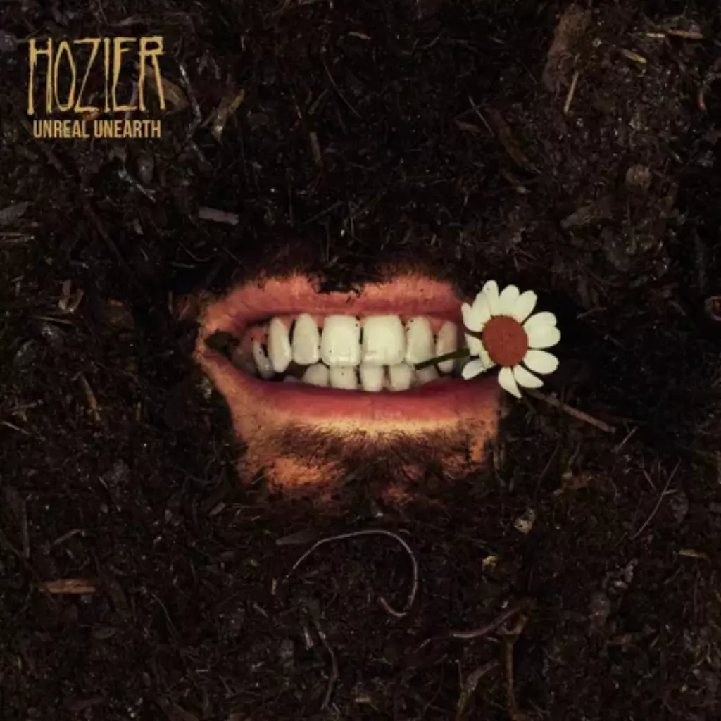 Unreal unearth album cover. A face biting a daisy having its face buried in soil except the mouth