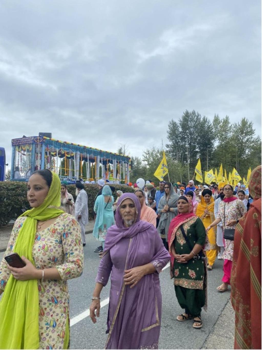 Nagar Kirtan Parade celebration. Many people are dressed in vibrant traditional outfits while some are marching with sikh flags