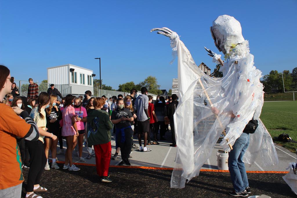A person in a ghost costume in scaring children