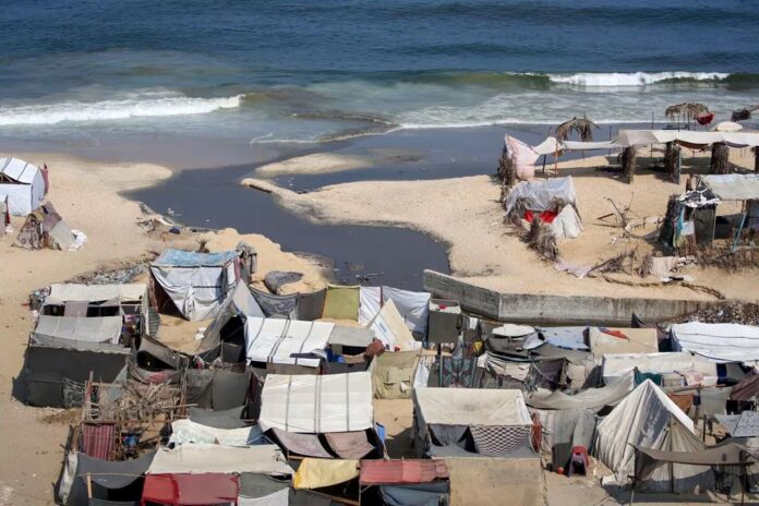 A stream of untreated sewage from a temporary tent camp flows into the Mediterranean Sea.